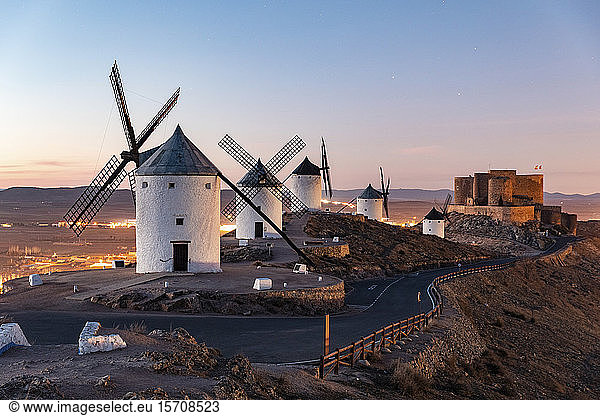Spanien  Provinz Toledo  Consuegra  Straße entlang einer Reihe alter Windmühlen  die auf einem Hügel stehen