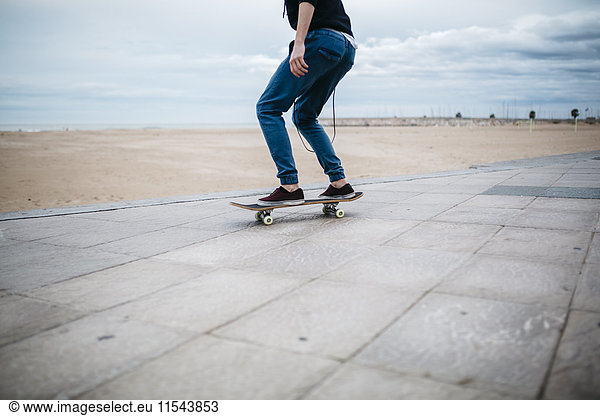 Spanien  Torredembarra  junger Skateboarder vor dem Strand  Teilansicht
