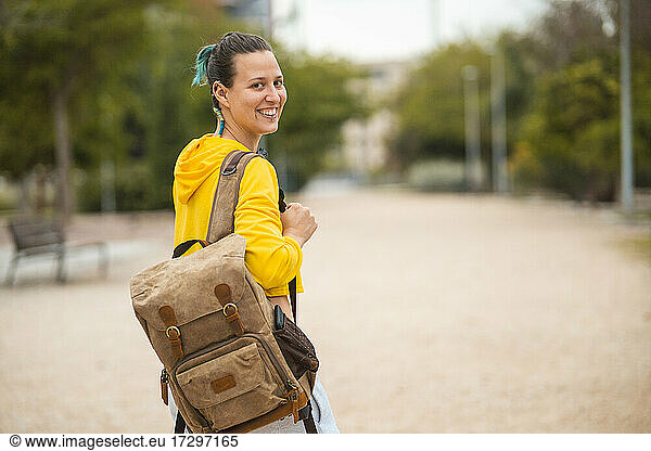 Spanische Studentin mit Rucksack und Lächeln im Rücken
