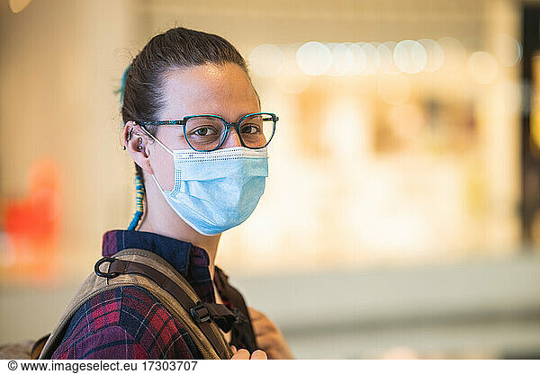 Spanish woman with mask and glasses shopping in mall with copy space