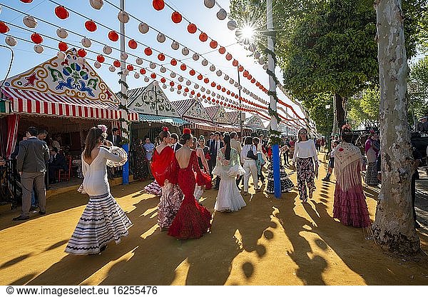 Spanish women with colorful flamenco dresses in front of marquees  Casetas  Feria de Abril  Sevilla  Andalusia  Spain  Europe