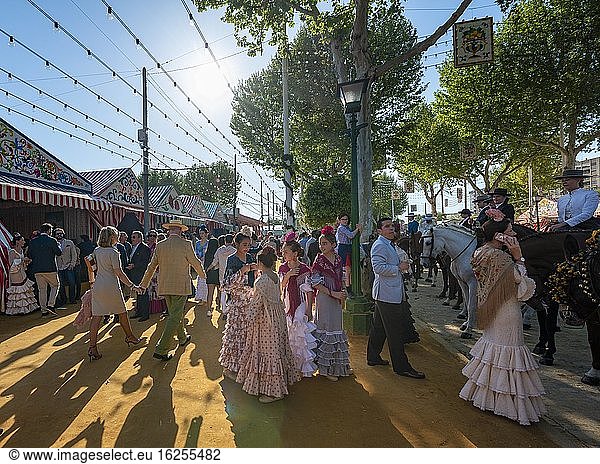 Spanish women with colorful flamenco dresses in front of marquees  Casetas  Feria de Abril  Sevilla  Andalusia  Spain  Europe