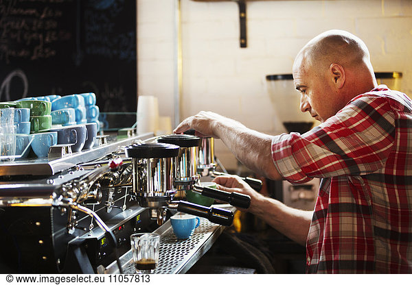 Specialist coffee shop. A man working a coffee machine making coffee.