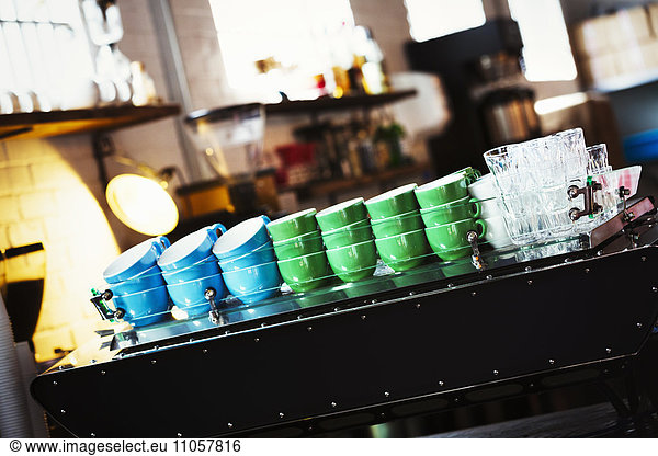 Specialist coffee shop. Blue and green coffee cups stacked up on the counter.
