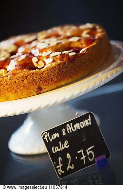 Specialist coffee shop. Plum and almond cake on a cake stand.