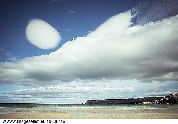 Spectacular sky with clouds over ocean and pristine beach