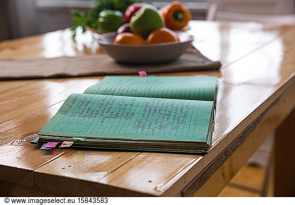Spices and old recipe book on wooden background on kitchen.