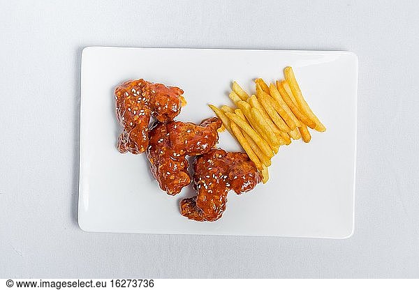 Spicy Hot Buffalo Wings und Pommes frites mit weißer Soße auf weißem Teller isoliert weißem Hintergrund. Ansichten von oben.