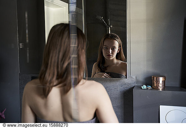 Spiegelbild eines nachdenklichen Mädchens im Badezimmer