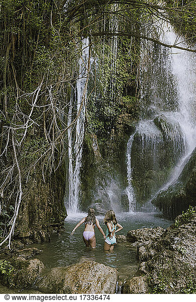 Spielende Mädchen beim Erkunden eines Wasserfalls