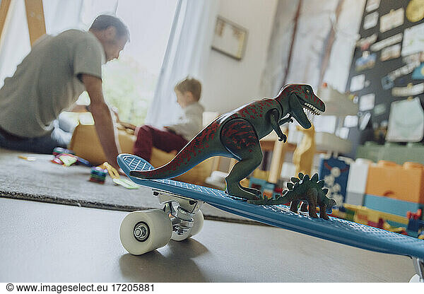 Spielzeug-Dinosaurier auf Skateboard im Schlafzimmer