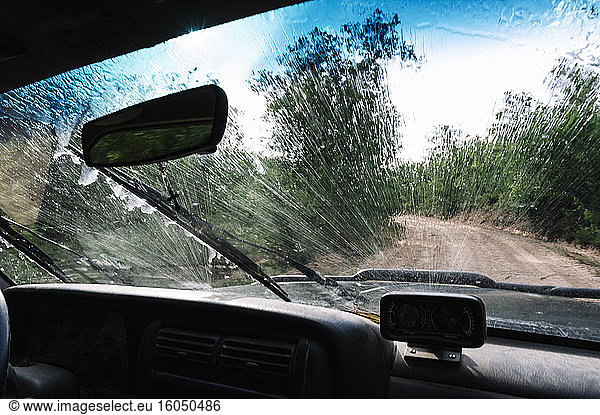 Splashing water on vehicle windshield during road trip