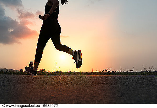 Sport Frau läuft auf einer Straße. Fitness Frau Training bei Sonnenuntergang