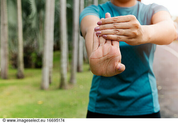 sport woman stretching forearm before exercising. outdoor sport