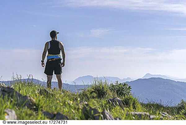 Sportler betrachtet die Aussicht  während er auf einem Berg steht
