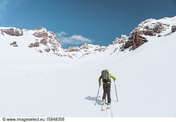 Sportler  der sich bei Sonnenschein in Richtung Berge häutet