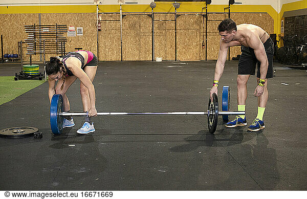 Sportler fit Mann und Frau ändern Gewichte der Langhantel bei der Vorbereitung Fitness-Studio Ausrüstung für das Training