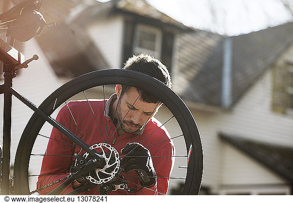 Sportler untersucht Fahrrad an sonnigem Tag