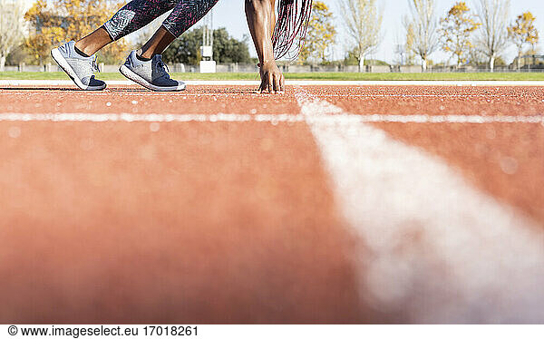 Sportlerin an der Startlinie auf der Laufstrecke an einem sonnigen Tag