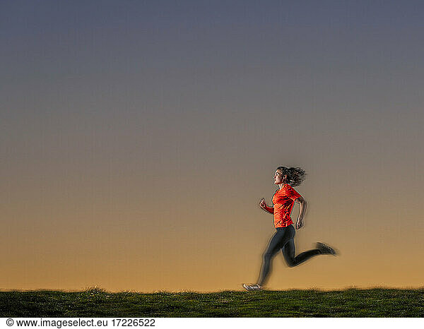 Sportlerin joggt bei Sonnenuntergang