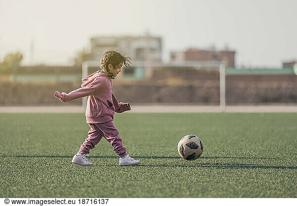 Sports kid. Happy little girl kid kicking a soccer ball  Child plays