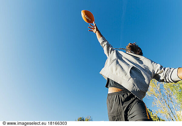Sportsman throwing American football on sunny day