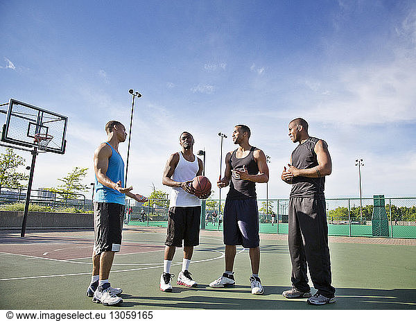 Sportsmen talking while standing in basketball court