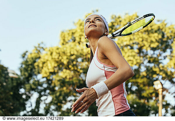 Sportswoman holding tennis racket at sports court