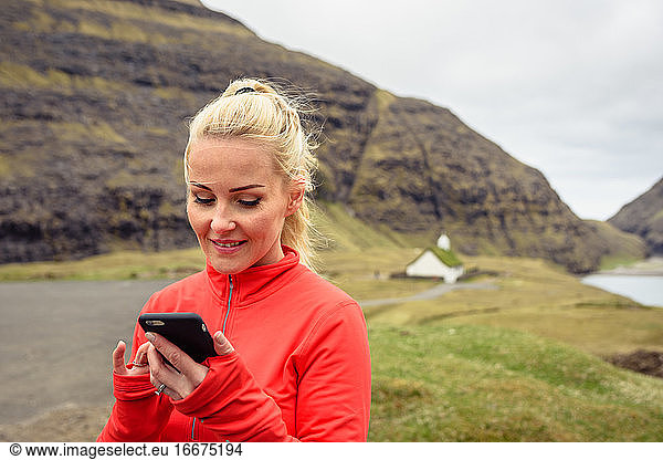Sportswoman using smartphone in countryside