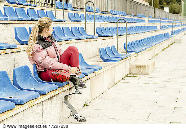 Sportswoman with disability sitting on stadium