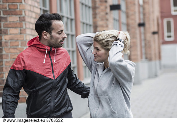 Sporty couple communicating on street