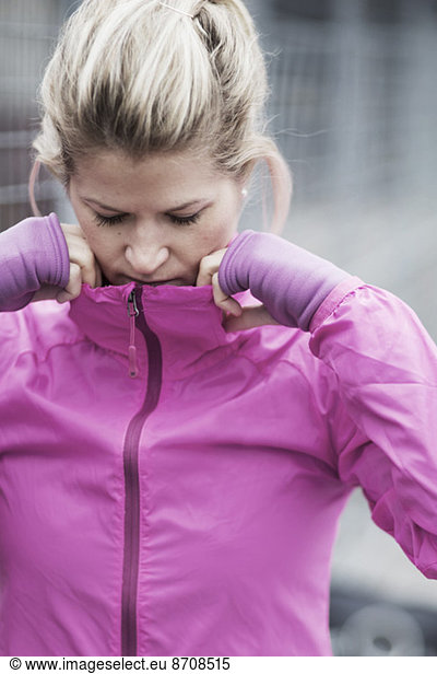 Sporty woman adjusting jacket's collar