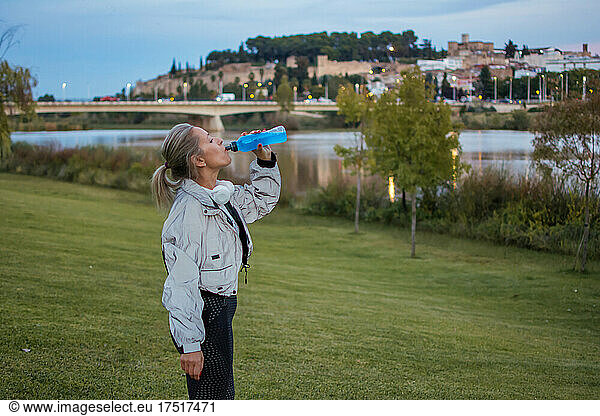 Sporty Woman Drinking Isotonic Beverage. Daily Exercise Routine