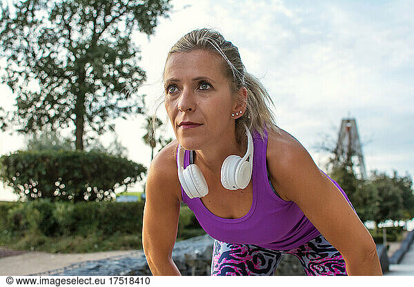 Sporty Woman Resting Has White Headphones. Daily Exercise Routine