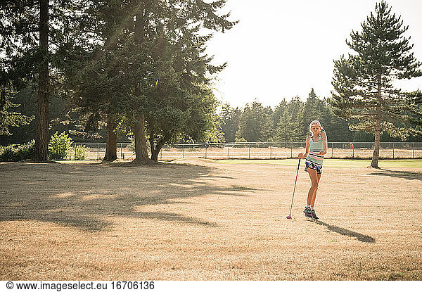 Sporty young girl on golf fairway celebrating after a good drive