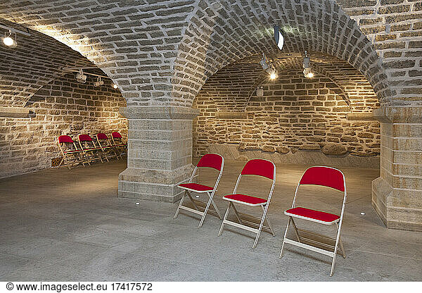 Stühle in einem gewölbten Steinsaal für Vorlesungen  Sitzungen oder Seminare an einer Universität