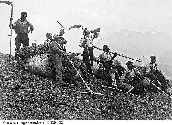 St. Moritz  Schweiz  1931
Eine Gruppe von Heumachern legt am Berghang eine Pause ein  um sich zu erfrischen.