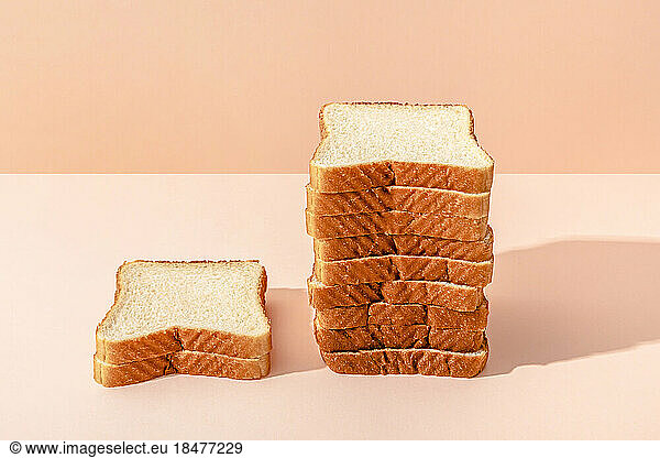Stack of bread slices against peach background