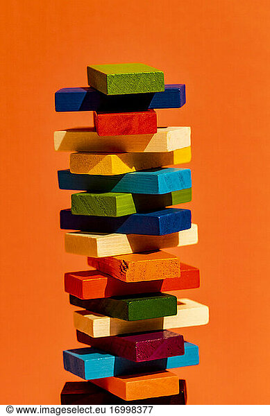 Stack of colorful construction blocks against orange background