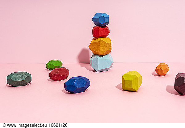 Stack of multi colored wooden block against pink background
