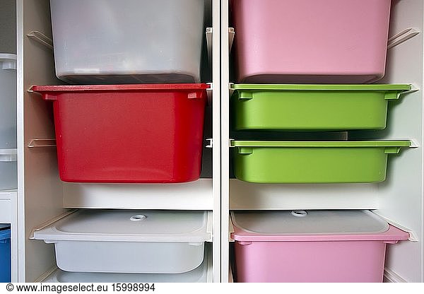 Stack of plastic storage boxes in different colors  sorting system arrangement close-up.