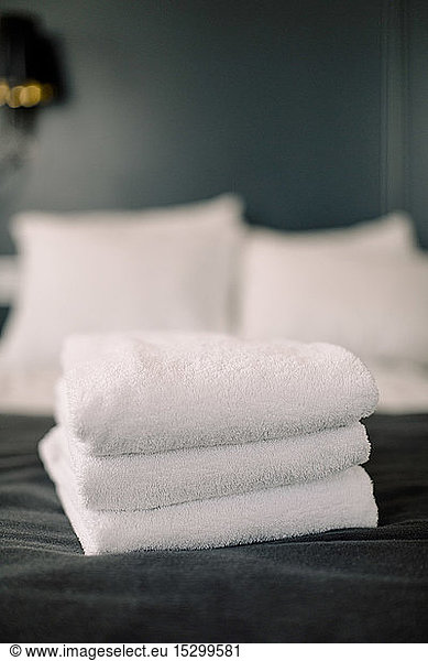 Stack of towels on bed in hotel