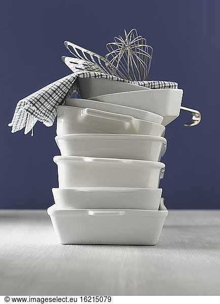 Stacked casseroles  dishcloth  eggbeater and fish slice