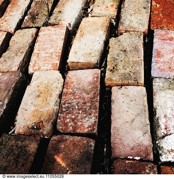 Stacks of bricks  worn and aged  arranged in rows  for reuse.