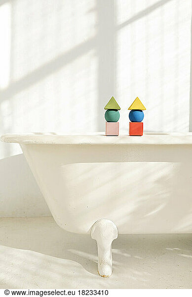 Stacks of toy blocks standing on bathtub rim