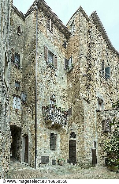 Stadtbild mit alten hohen Gebäuden auf einem kleinen Hof einer historischen Stadt  aufgenommen in hellem Licht in Pienza  Siena  Toskana  Italien.