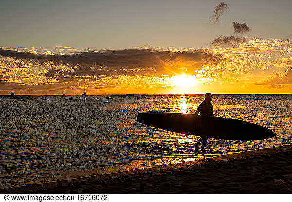 Stand Up Paddle Board bei Sonnenuntergang einpacken