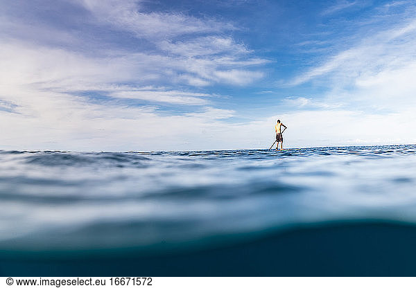 Stand Up Paddler paddelt allein auf dem Ozean von Hawaii