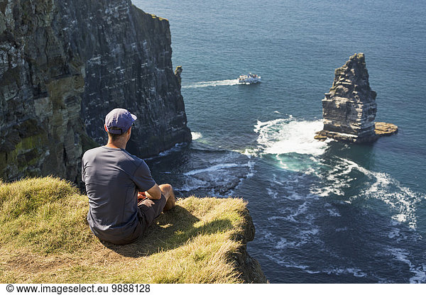 Stapel Felsbrocken sitzend Mann Ecke Ecken Gebäude Ozean Tagesausflug Boot Meer Ignoranz groß großes großer große großen Wiese Clare County Irland Felssäule