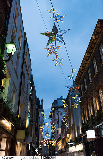Star shape christmas decorations above city street at dusk  London  UK